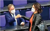  ?? FOTO: TOBIAS SCHWARZ / AFP ?? Grünen-chefin Annalena Baerbock begrüßt Armin Laschet im Plenum.