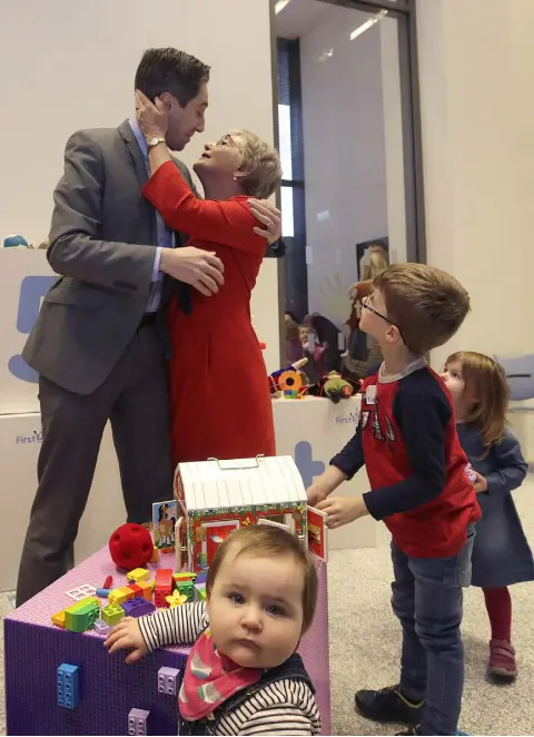  ?? Photo: Damien Eagers ?? THE DANCE OF POLITICS: Minister for Children Katherine Zappone greets Minister for Health Simon Harris at a Fine Gael policy launch, as five-year-old Tadgh Litton and some younger children look on.