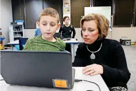  ?? [PHOTOS BY CORY YOUNG, TULSA WORLD] ?? Shannon Troxel, at right, a teacher at EPIC Tulsa’s Blended Learning Center, assists student Silas Brown, 8, on Thursday.