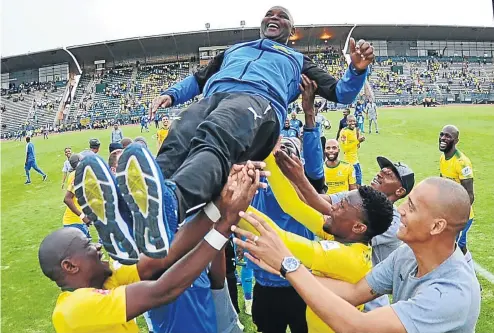  ??  ?? Olé! Olé! Olé! Pitso Mosimane is hoisted high by his players as Sundowns win the PSL crown with one game to go.