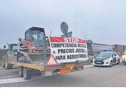  ?? ?? Un tractor con un cartel delante de uncoche de la Guardia Civil.