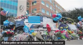  ??  ?? A Dallas police car serves as a memorial on Sunday.