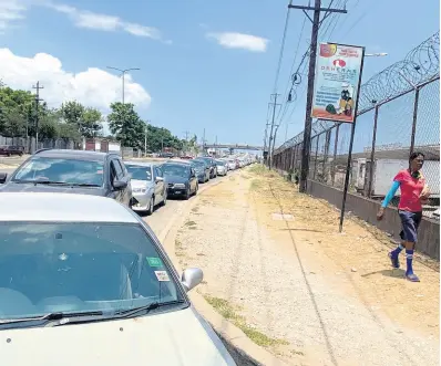  ?? RICARDO MAYKN/PHOTOGRAPH­ER ?? Numerous motorists were seen awaiting their turn to enter the AMC complex on Spanish Town Road for the Drive-Thru Farmers’ Market on Wednesday.