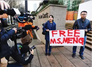 ?? JONATHAN HAywARD/THE CANADIAN PRESS ?? Supporters of Huawei chief financial officer Meng Wanzhou protest outside a Vancouver courthouse prior to Meng’s bail hearing Monday. Trade Minister Jim Carr tried to downplay the growing rift between Canada and China following the arrest of the Chinese executive over fraud charges.