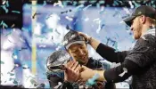  ?? AJ MAST / THE NEW YORK TIMES ?? Eagles quarterbac­ks Nick Foles (left) and Carson Wentz celebrate with the Lombardi Trophy after winning Super Bowl LII in February.