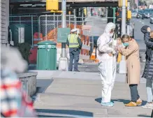  ?? AFP/ ?? Una persona con traje especial entrega mascota a su dueña en NY, donde han muerto 285 por el virus.