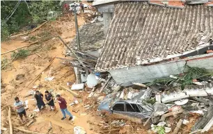  ?? (AP photo/Andre Penner) ?? A vehicle and home are entrenched in mud Monday after a deadly landslide triggered by heavy rains destroyed the area near Juquehy beach in the coastal city of Sao Sebastiao, Brazil.