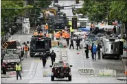  ?? ELAINE THOMPSON - THE ASSOCIATED PRESS ?? Police and city workers fill a street occupied hours earlier by an encampment of protesters Wednesday, July 1, in Seattle, where streets had been blocked off in an area demonstrat­ors had occupied for weeks.