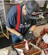  ??  ?? Competitio­n pitmaster and Burnt Bean co-owner Ernest Servantes cuts pork chops.