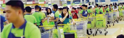  ??  ?? EMPLOYEES load up shopping carts at a supermarke­t in Parañaque City. According to Morgan Stanley, the Philippine economy is seeing a “recovery in domestic demand alongside supportive external demand.”