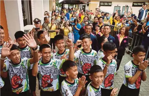  ??  ?? REMAJA itu melambai kepada orang ramai yang menyambut kedatangan mereka untuk menghadiri sidang media di Chiang Rai semalam. - Reuters