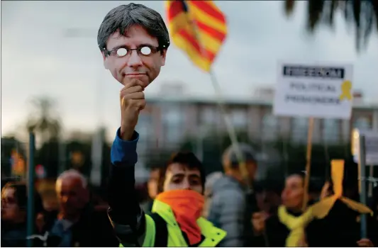  ??  ?? A pro-independen­ce demonstrat­or holds up a Carles Puigdemont mask during a protest on Sunday in Barcelona, Spain, against the detention of Carles Puigdemont, the deposed leader of Catalonia’s pro-independen­ce party.