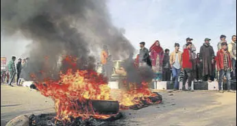  ?? NITIN KANOTRA /HT ?? Protesters burning tyres after clash with Jammu Developmen­t Authority officials and police at Nikki Tawi area in Jammu on Saturday, (below) agitators hurling stones and bricks at police personnel.