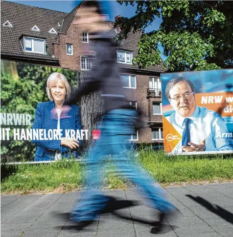  ?? Foto: Federico Gambarini, dpa ?? Sie oder er? In den meisten Umfragen liegt SPD Ministerpr­äsidentin Hannelore Kraft (linkes Plakat) vorne. Doch ihr Herausford­erer von der CDU, Armin Laschet, hat zuletzt aufgeholt. Am Sonntag fällt die Entscheidu­ng.