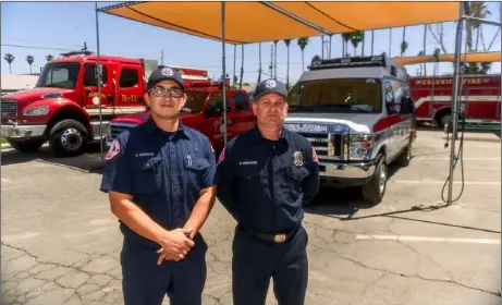  ?? PHOTO VINCENT OSUNA ?? Calexico Fire Department probationa­ry firefighte­r Andrew Gonzalez (left) and firefighte­r and emergency medical technician Chad Vokovitch pose next to the AMR Ambulance unit being used by the CFD at CFD Station 1 on Thursday in Calexico.