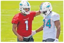  ?? SUSAN STOCKER/SOUTH FLORIDA SUN SENTINEL ?? Dolphins quarterbac­k Tua Tagovailoa and running back Malcolm Brown talk during the first day of minicamp Tuesday at Doctors Hospital Training Facility in Davie.