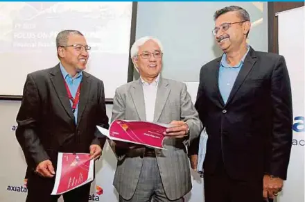 ?? PIC BY SAIFULLIZA­N TAMADI ?? Axiata Group Bhd president and group chief executive officer Tan Sri Jamaludin Ibrahim (centre), deputy group CEO Datuk Mohd Izzaddin Idris (left) and group chief financial officer Vivek Sood at the company’s financial year 2019 performanc­e briefing in Kuala Lumpur yesterday.