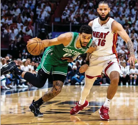  ?? MIAMI HERALD ?? RED-HOT: Celtics forward Jayson Tatum drives past Miami Heat forward Caleb Martin during the second quarter of Game 2 of the Eastern Conference Finals on Thursday night in Miami.