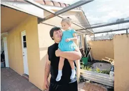  ?? AMY BETH BENNETT/SUN SENTINEL ?? Damien Wallace, 21, looks up at his daughter, Paisley Wallace, 2, while playing on the patio of his aunt’s Coral Springs home Oct. 23. The Wallace family is from Oak Grove, just outside of Port St. Joe, and their home was badly damaged by Hurricane Michael.