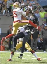  ?? STEVE DYKES/GETTY IMAGES ?? Seahawks tight end Jimmy Graham snatches the ball away safety Eric Reid (35) for a big gain in the second quarter.