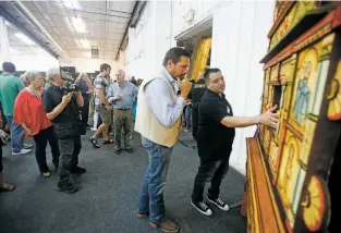  ?? PHOTOS BY LUIS SÁNCHEZ SATURNO/THE NEW MEXICAN ?? The best of show winner Nicolás Otero shows his piece to Mayor Javier Gonzales on Friday during the Traditiona­l Spanish Market preview at El Museo Cultural.