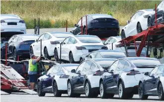  ?? AP PHOTO/ BEN MARGOT ?? Tesla cars are loaded onto carriers at the Tesla electric car plant in Fremont, Calif., in May.