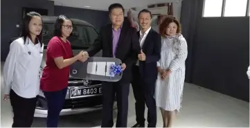  ??  ?? Ho (centre) presents the mock key to the new Proton Etika to Andy’s representa­tive, witnessed by Lau (second right), Hii (right) and a Proton sales member.