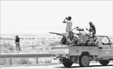  ?? Mahmud Turkia AFP/Getty Images ?? FORCES LOYAL to Libya’s U.N.-backed unity government wait on Friday at the entrance of Surt in the effort to recapture the city from Islamic State fighters. Militia fighters have reportedly taken over Surt’s port.