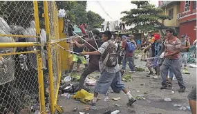  ??  ?? Rompen valla. Cientos de migrantes centroamer­icanos que forman parte de una segunda caravana rumbo a EUA se enfrentan a la policía en el paso con México.