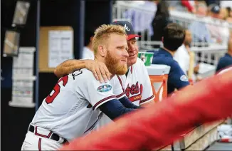  ??  ?? Braves pitching coach Chuck Hernandez (right) talks with starting pitcher Mike Foltynewic­z in the fourth inning Monday in Atlanta. Foltynewic­z, pitching on short rest for the first time in 2018, went four innings, holding the Dodgers to one run.