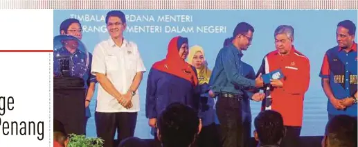  ?? PIC BY DANIAL SAAD ?? Deputy Prime Minister Datuk Seri Dr Ahmad Zahid Hamidi presenting a MyKad to a recipient at the ‘Turun Padang’ programme in Kepala Batas, Penang, yesterday. With him are state Umno liaison committee chairman Datuk Seri Zainal Abidin Osman (second from...