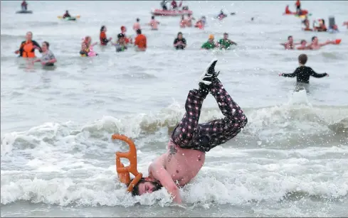  ?? FRANCOIS LENOIR / REUTERS ?? A reveller enjoys himself in the bitterly cold waters of the North Sea at the annual New Year’s Plunge event in Ostend, Belgium, on Saturday.