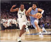  ?? Tom Pennington / Getty Images ?? North Carolina’s R.J. Davis, right, drives with the ball as Baylor’s Dale Bonner defends in overtime of their second-round NCAA Tournament game Saturday at Dickies Arena in Fort Worth, Texas.