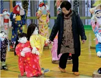  ??  ?? These pictures taken on March 16, 2019 show local resident Tsukimi Ayano inspecting life-size dolls at her workshop in the tiny village of Nagoro in western Japan. In the tiny village, deep in the mountains of western Japan, the wind howls down a deserted street with not a living soul to be seen. But yet the street appears busy, dotted with life-sized dolls that outnumber humans 10 to one