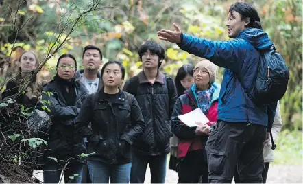  ?? — THE CANADIAN PRESS ?? Ken Wu, right, of the Ancient Forest Alliance, speaks to a group of educationa­l tour guides during training for Chinese-language ancient forest tours, at Stanley Park on Saturday.