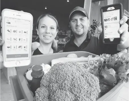  ?? NICK BRANCACCIO ?? Kathy Mastronard­i-Black and Michael Mastronard­i of Lee and Maria’s display their phone app launched recently for the purchase and delivery of local farm-fresh produce and groceries. The app is designed for mobile devices and tablets.