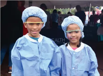  ?? JESI YOST - FOR MEDIANEWS GROUP ?? Treyvon, 8, and Trinity Ragland, 6, of Pottstown, wear bouffant caps (surgical head coverings), goggles, and scrub jackets at the Pottstown Hospital – Tower Health Community Festival.