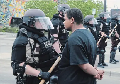  ?? JIM MONE THE ASSOCIATED PRESS ?? A protester goes face-to-face with a Minnesota state trooper on Friday after another night of protests over the death of George Floyd, a Black man who died in police custody on Monday in Minneapoli­s.