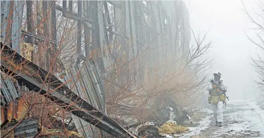  ?? [ Reuters ] ?? Patrouille an der „Kontaktlin­ie“. Ein ukrainisch­er Soldat geht an den Barrikaden vorbei, die an der Grenze zu den Separatist­engebieten errichtet wurden.