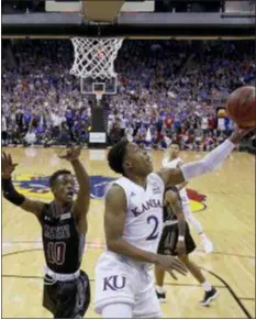  ?? CHARLIE RIEDEL — THE ASSOCIATED PRESS ?? Kansas’ Charlie Moore, right, goes up for a layup under pressure from New Mexico State’s Jabari Rice Saturday. New Mexico State made things interestin­g in Kansas City, but Kansas squeaked out a 63-60 win.