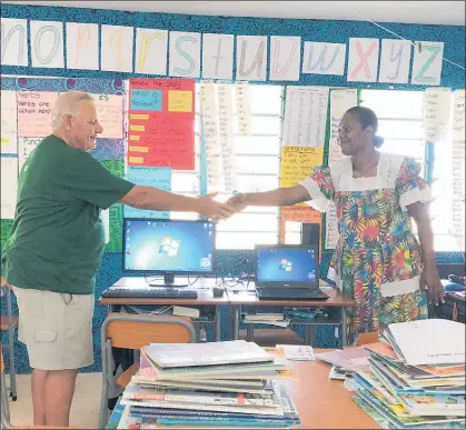  ??  ?? LOCAL Rotarian John Buchanan presenting two computers to Fiona, head teacher at the Victory School of Hope in Port Vila.