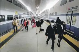  ?? Luis Sinco Los Angeles Times ?? PASSENGERS at Metrolink’s Union Station in April. Los Angeles County is on track to see a new universal indoor mask order by early July, recent data show.