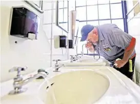  ?? Steve Helber / Associated Press file ?? State worker Al Jones tests the water in the state Capitol in Charleston, W.Va. A chemical spill has put the spotlight on other water woes in the state.