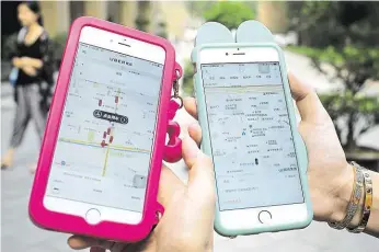 ?? Služba Uber (na snímku vlevo) je v někdejší říši středu mnohem méně rozšířená než konkurenčn­í domácí taxislužba Titi Čchusing (vpravo). Uber proto nakonec souhlasil se sloučením, i když jeho značka v Číně nezanikne. FOTO ČTK ?? V Číně spolu.