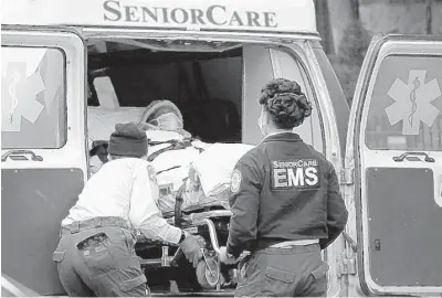  ?? JUSTIN HEIMAN/GETTY ?? Paramedic workers unload a patient out of their ambulance April 18 in the Brooklyn borough of New York City.