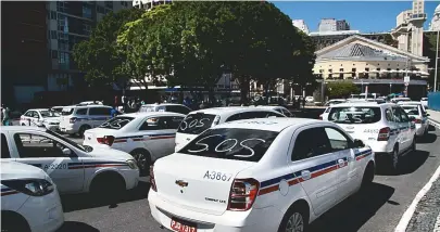  ??  ?? Táxis passam pelo Mercado Modelo, em carreata saindo do ferry, em direção ao Palácio Thomé de Souza