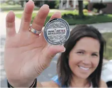  ??  ?? Windsor triathlete Nikki LeBlanc holds a medal from the Ohio race where she qualified for the Ironman 70.3 World Championsh­ips in South Africa.