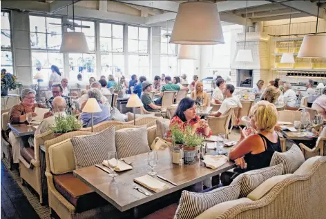  ?? Photos by John Storey / Special to The Chronicle ?? The 70-seat dining room at French Blue is stunning with a pitched roof and exposed beams, wicker chairs and pendant-shaded lamps.