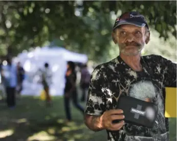  ?? RICHARD LAUTENS/TORONTO STAR ?? Resident Clifford checks out a naloxone (anti-overdose) kit he was given at the Moss Park pop-up clinic.