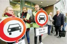  ?? — Reuters ?? Juergen Resch (R), head of the German environmen­tal help group (Deutsche Umwelthilf­e) uses his mobile phone before a court hearing on case seeking diesel cars ban in Berlin on Tuesday. The signs read ‘Applies to diesel.’